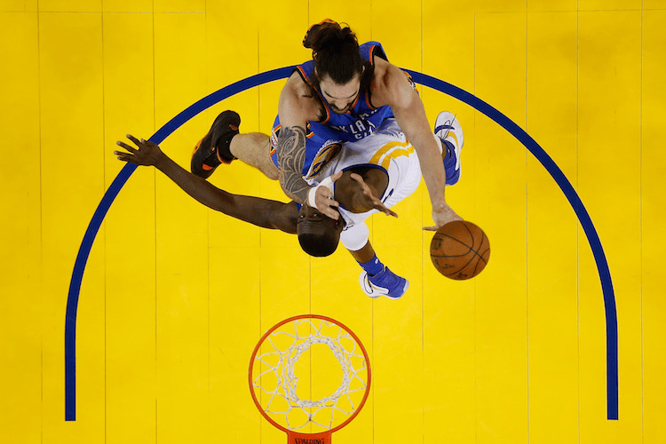 OAKLAND, CA - MAY 16:  Steven Adams #12 of the Oklahoma City Thunder attempts a shot against Draymond Green #23 of the Golden State Warriors during game one of the NBA Western Conference Finals at ORACLE Arena on May 16, 2016 in Oakland, California. The Thunder defeated the Warriors 108-102. NOTE TO USER: User expressly acknowledges and agrees that, by downloading and or using this photograph, User is consenting to the terms and conditions of the Getty Images License Agreement.  (Photo by Christian Petersen/Getty Images)