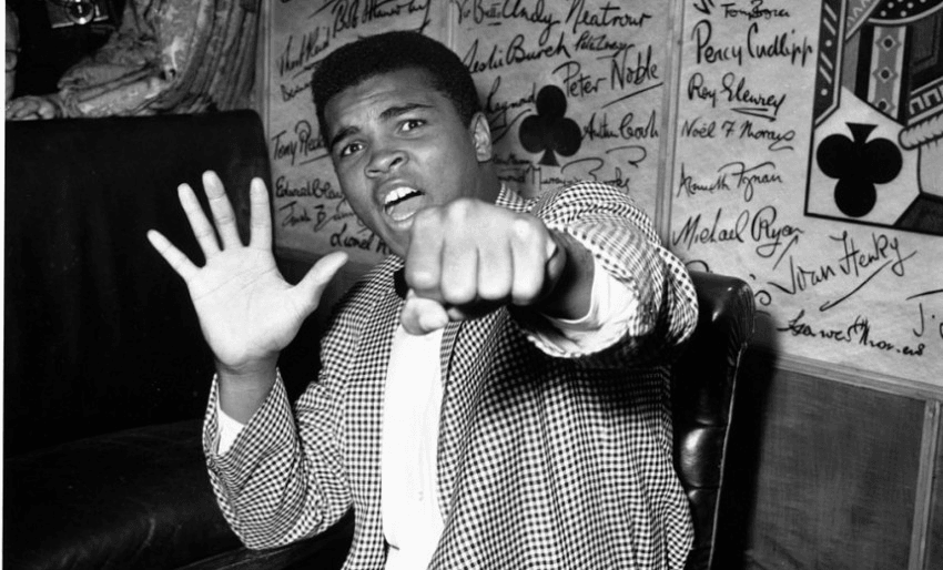 27th May 1963:  Supremely confident American boxer Cassius Clay holds up five fingers in a prediction of how many rounds it will take him to knock out British boxer Henry Cooper.  (Photo by Kent Gavin/Keystone/Getty Images)