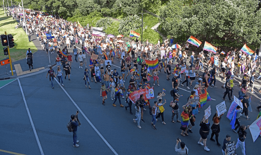 Three thousand marchers block Auckland central roads waving pride flags.