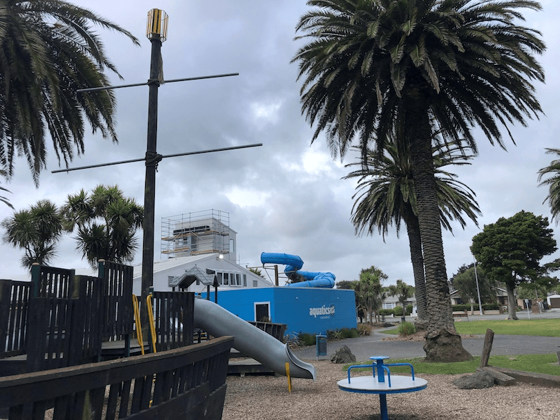 An empty playground and exterior of an aquatics centre.