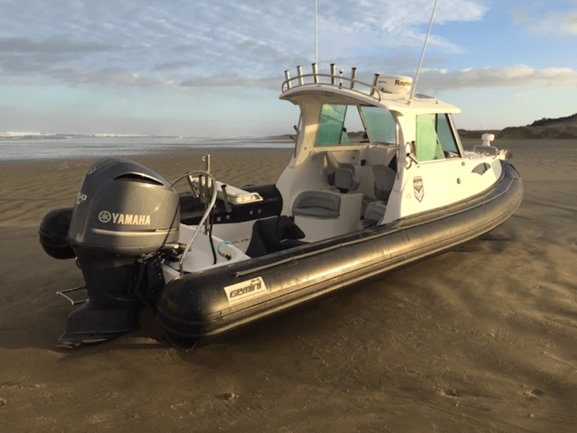 A inflatable boat pulled up on a beach. 